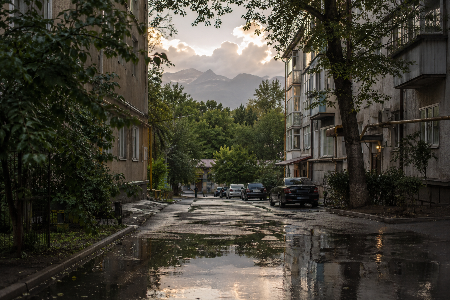 An Almaty courtyard after rain, where everyday scale meets the mountains.