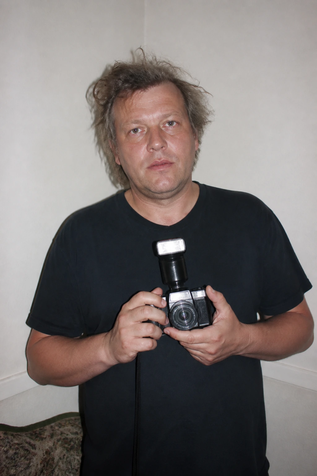 AI reconstruction of Juergen Teller with a compact camera and flash unit.